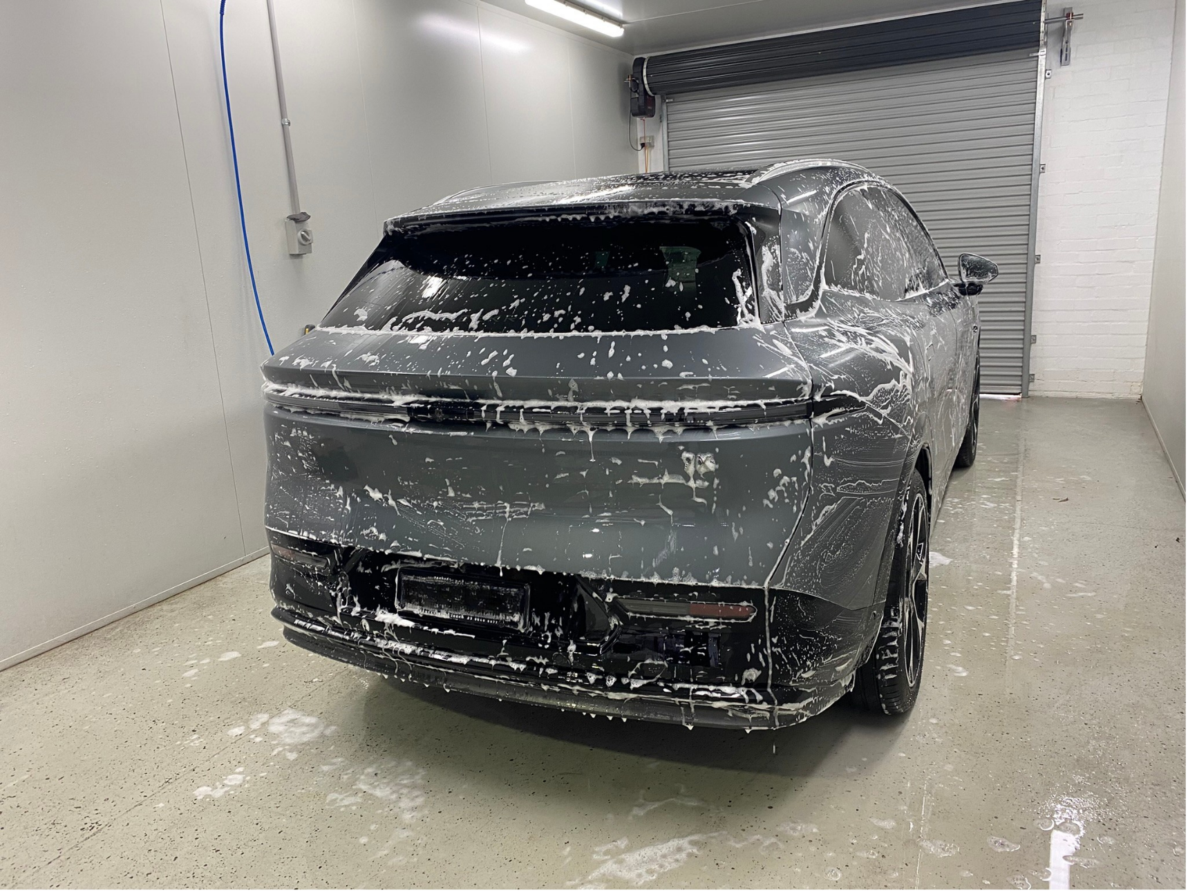 Grey ZEEKR undergoing post-repair exterior cleaning and detailing